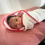 baby, blanket, comfort, cute, eyes, face, hand, indoors, infant, lying_down, newborn, person, pink_cushion, portrait, relaxed, resting, skin, soft, towel, wrapped