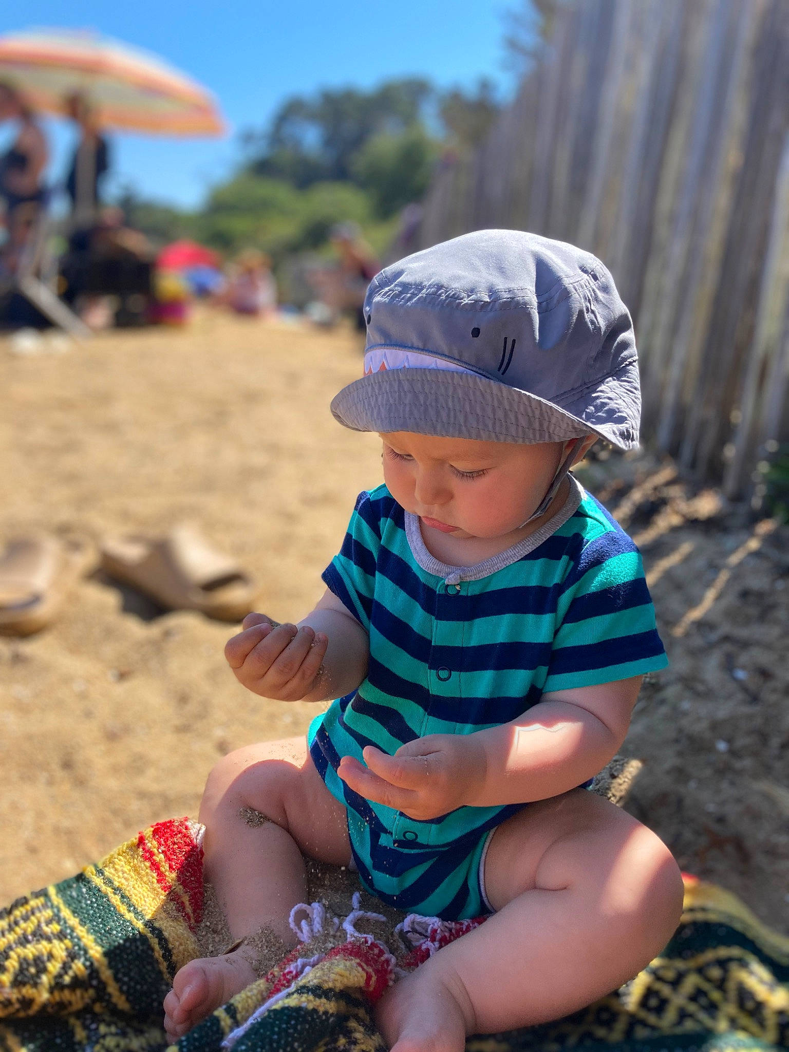 Luka joined the competition — help win amazing prizes! baby_toddler_clothing, beach, cap, child, clothing, fun, grass, happy, hat, headwear, leg, leisure, people, people_in_nature, person, sand, shorts, sitting, sky, summer