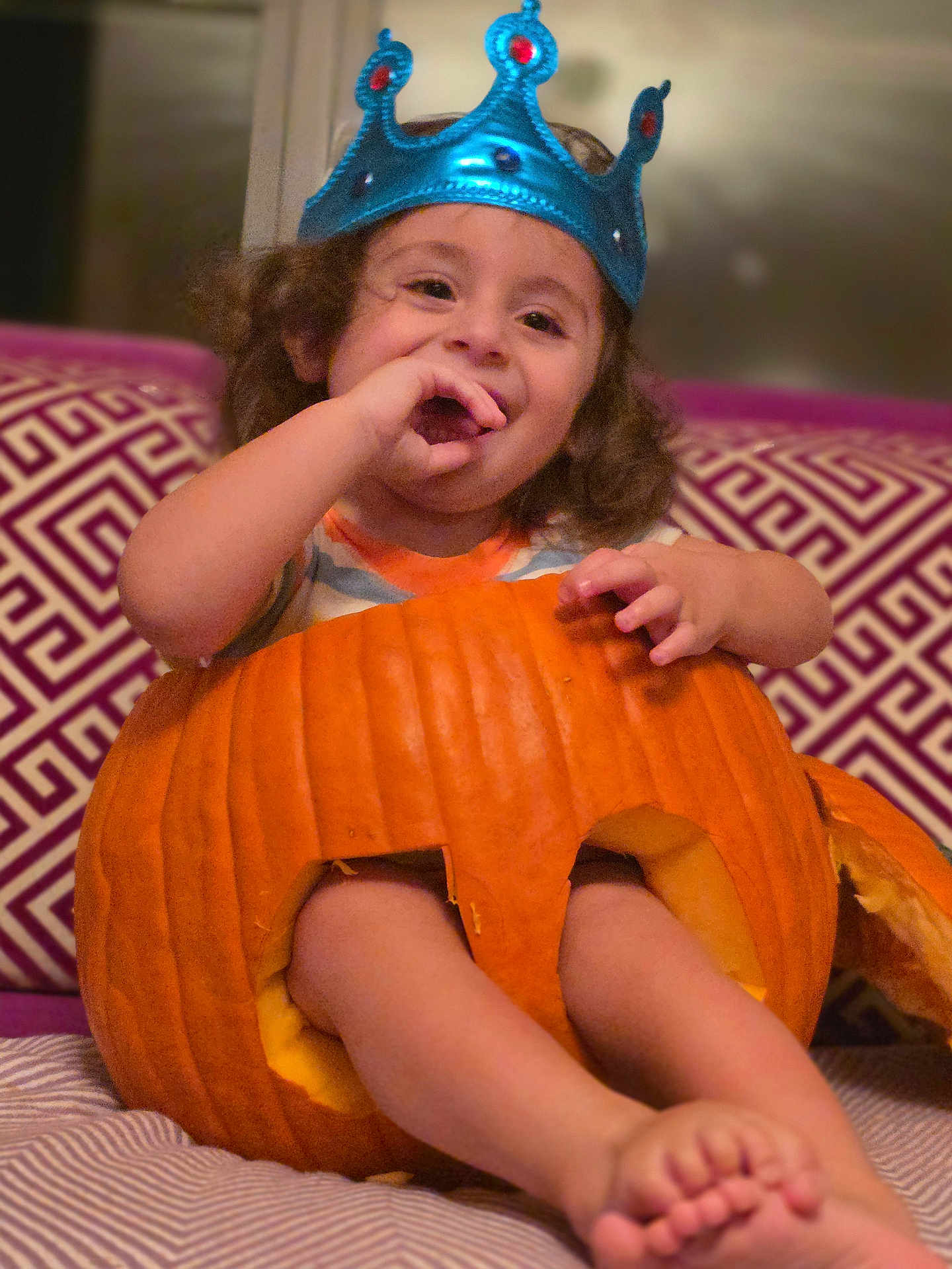 Brando joined the competition — help win amazing prizes! toddler, child, pumpkin, crown, smile, happy, indoor, furniture, couch, pattern, legs, feet, curly_hair, orange, playful, portrait, cute, cozy, holiday, fun