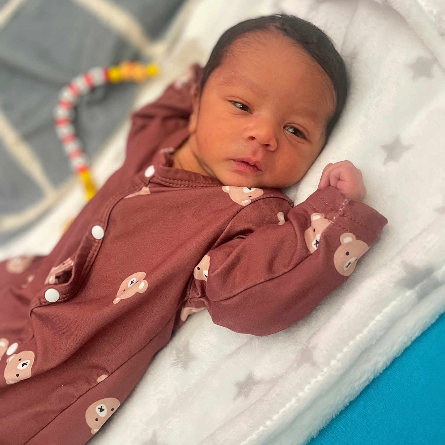 Joahkim a rejoint le concours — aidez-le/la à gagner de superbes lots ! baby, bear_pattern, blanket, child, colorful, cozy, curious, cute, face, indoors, infant, lying_down, newborn, onesie, portrait, resting, sleepwear, soft_texture, star_pattern, toy