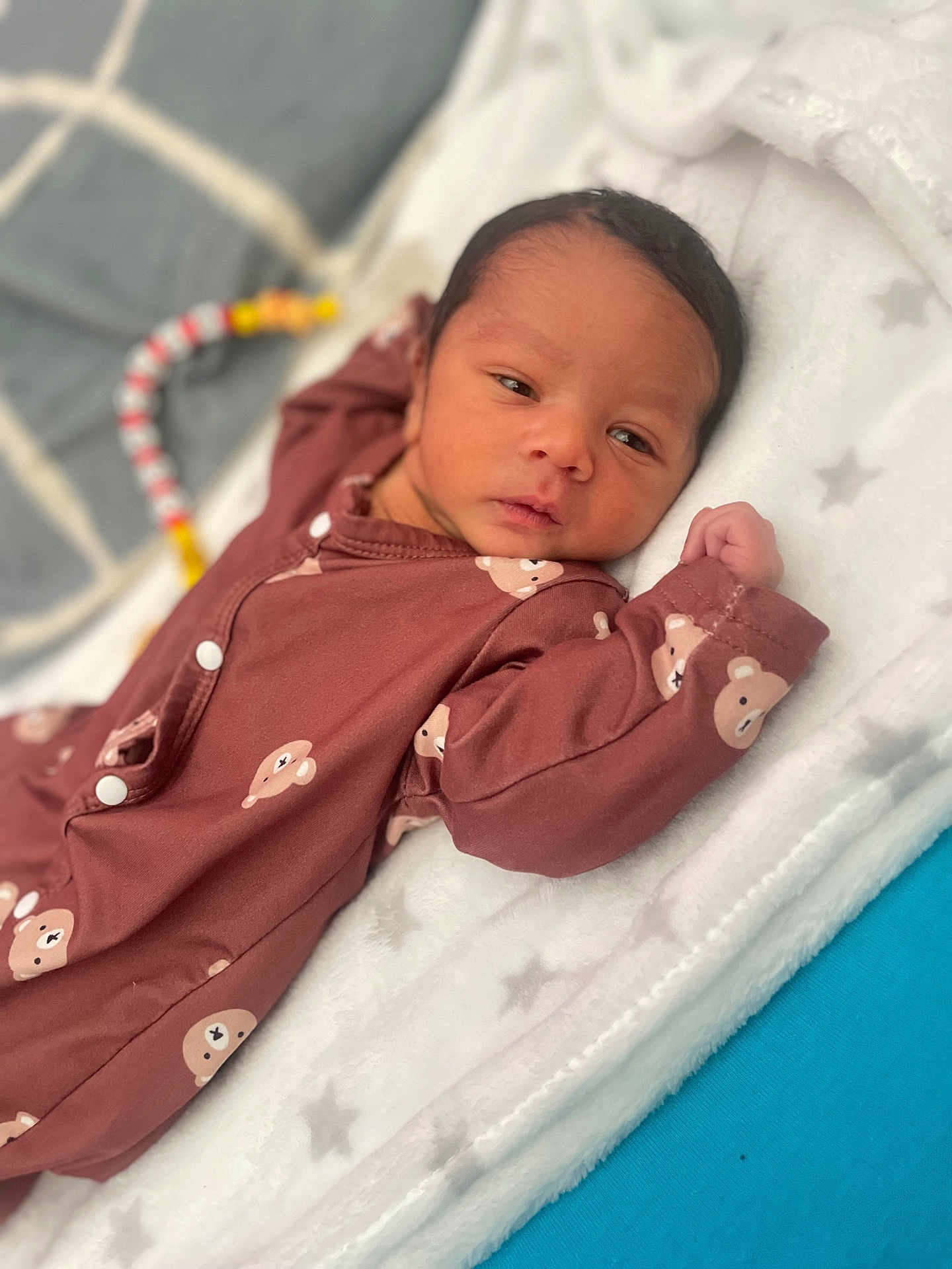 Joahkim a rejoint le concours — aidez-le/la à gagner de superbes lots ! baby, bear_pattern, blanket, child, colorful, cozy, curious, cute, face, indoors, infant, lying_down, newborn, onesie, portrait, resting, sleepwear, soft_texture, star_pattern, toy
