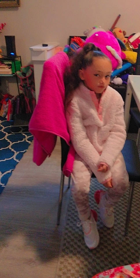 Giana joined the competition — help win amazing prizes! chair, child, event, face, floor, flooring, foot, fun, fur, fur_clothing, furniture, head, human_leg, knee, magenta, person, pink, room, smile, thigh