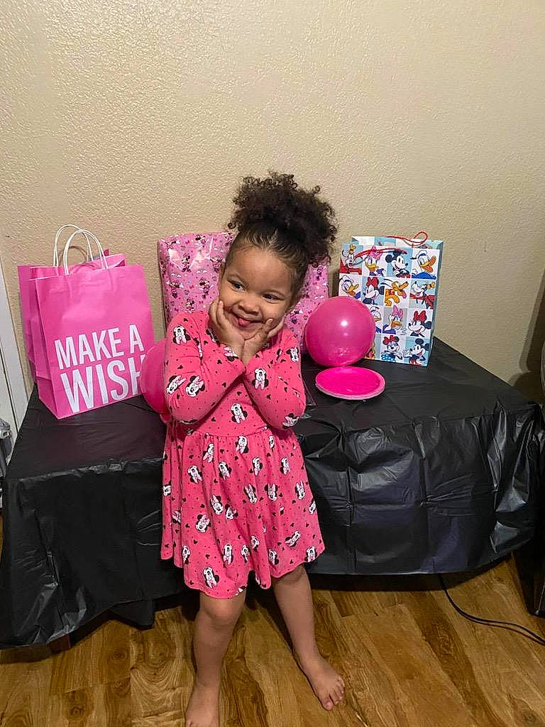 Kianna is registered to the contest to win money with this photo: baby_toddler_clothing, bag, barefoot, box, comfort, event, flooring, happy, hardwood, human_leg, joy, luggage_and_bags, magenta, pattern, person, pink, sitting, sleeve, smile, t_shirt