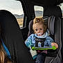bottle, car_interior, car_seat, child, cup, cup_holder, hair, jacket, looking_at_camera, milk, mountains, pacifier, road, seat, seat_belt, tablet, tablet_case, toddler, travel, window