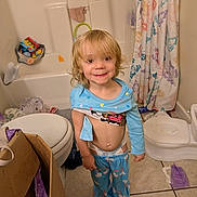 Maria is registered to the contest to win money with this photo: bath_toys, bathroom, bathroom_rug, bathtub, blond_hair, cardboard_box, child, cute, diaper, floor, pajamas, portrait, potty, shower_curtain, smile, standing, tiles, toddler, toilet, toys