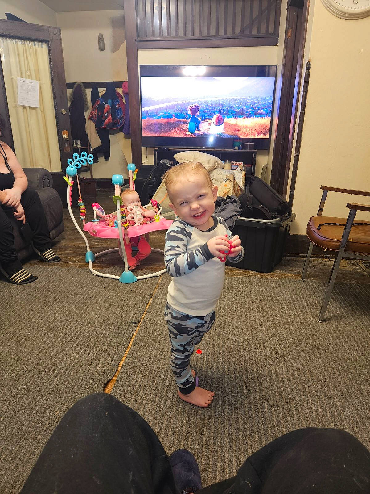 Connor is registered to the contest to win money with this photo: baby, child, clock, display_device, event, flooring, fun, holiday, home, joy, leisure, living_room, person, picture_frame, play, recreation, room, sitting, t_shirt, television