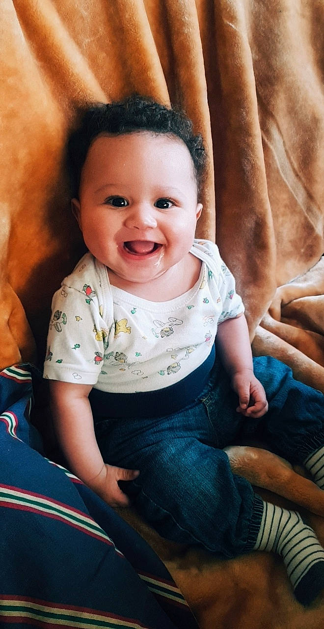 Dylan participe au concours pour gagner de l'argent avec cette photo : baby, cheek, child, eye, face, finger, happy, joy, person, sitting, skin, smile, toddler