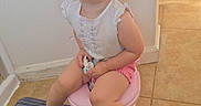 Vylette is registered to the contest to win money with this photo: toddler, child, smile, potty, bathroom, floor, tile, mat, pink, white_shirt, shorts, happy, sitting, barefoot, indoor, light, sunlight, young_child, cute, joy