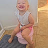 toddler, child, smile, potty, bathroom, floor, tile, mat, pink, white_shirt, shorts, happy, sitting, barefoot, indoor, light, sunlight, young_child, cute, joy