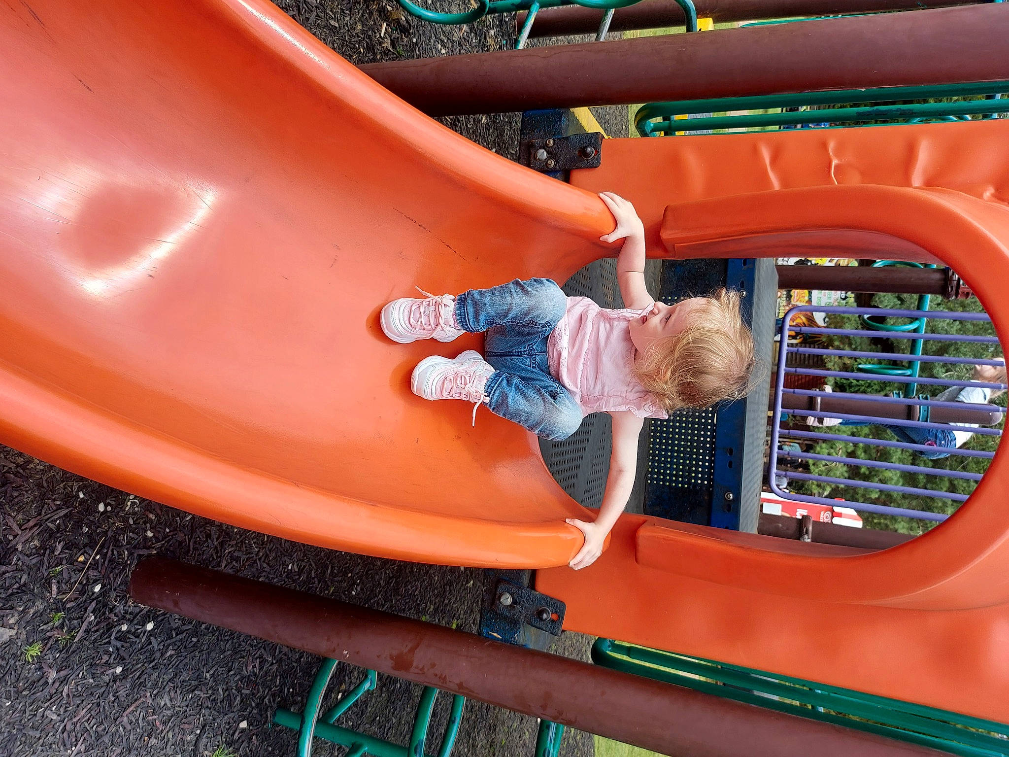 Davina is registered to the contest to win money with this photo: automotive_exterior, baby_toddler_clothing, blue, bumper, child, chute, city, electric_blue, fun, green, leisure, motor_vehicle, outdoor_play_equipment, person, play, playground, playground_slide, recreation, red, t_shirt