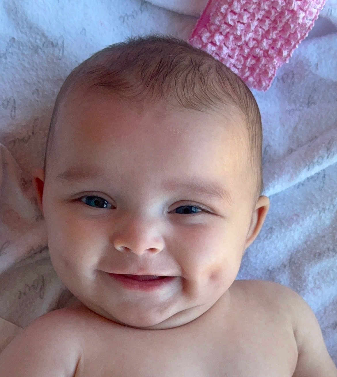 Calliope joined the competition — help win amazing prizes! baby, smile, dimples, face, head, eyes, skin, blanket, pink, knitted, soft, cozy, infant, child, portrait, lying_down, happy, cute, person, closeup