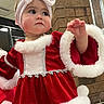 Oaklynn joined the competition — help win amazing prizes! toddler, child, girl, red_dress, christmas_outfit, headband, bow, indoor, brick_wall, window, curious_expression, holiday, festive_clothing, white_fur_trim, raising_hand, cute, portrait, person, holiday_season, fashion