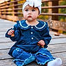 toddler, child, baby, headband, bow, blue_clothing, jeans, ripped_jeans, wooden_bridge, leaf, autumn, outdoor, sitting, cute, portrait, fall, nature, curious, young_child, casual_clothing