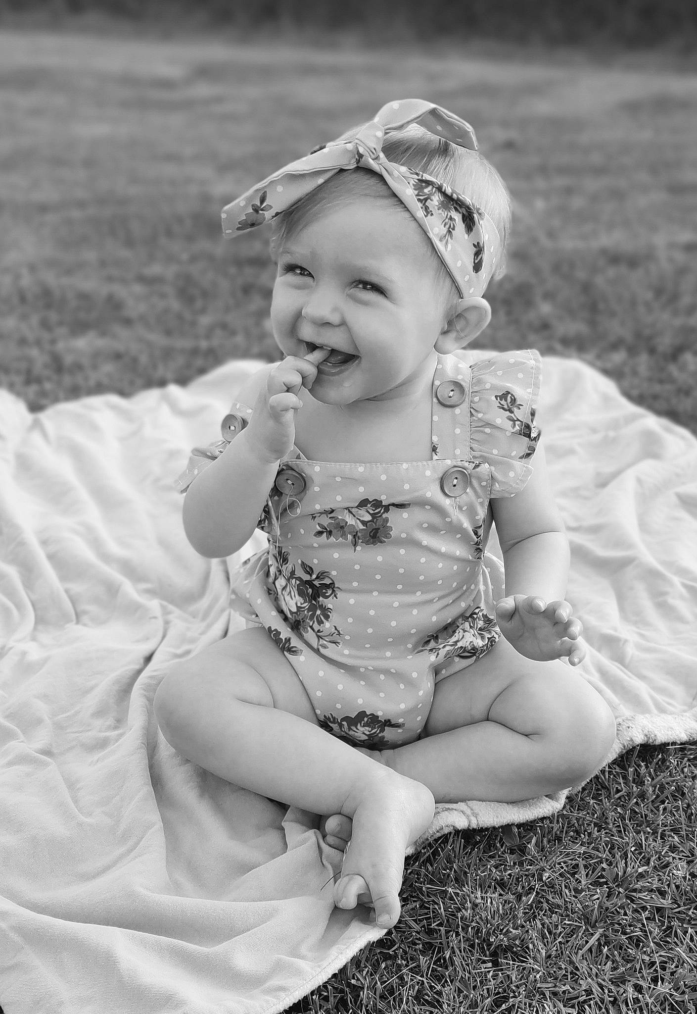 Saphirah joined the competition — help win amazing prizes! baby, baby_toddler_clothing, black_and_white, child, dress, face, flash_photography, fun, grass, grass_family, happy, headpiece, headwear, joy, monochrome, monochrome_photography, people_in_nature, person, sitting, smile