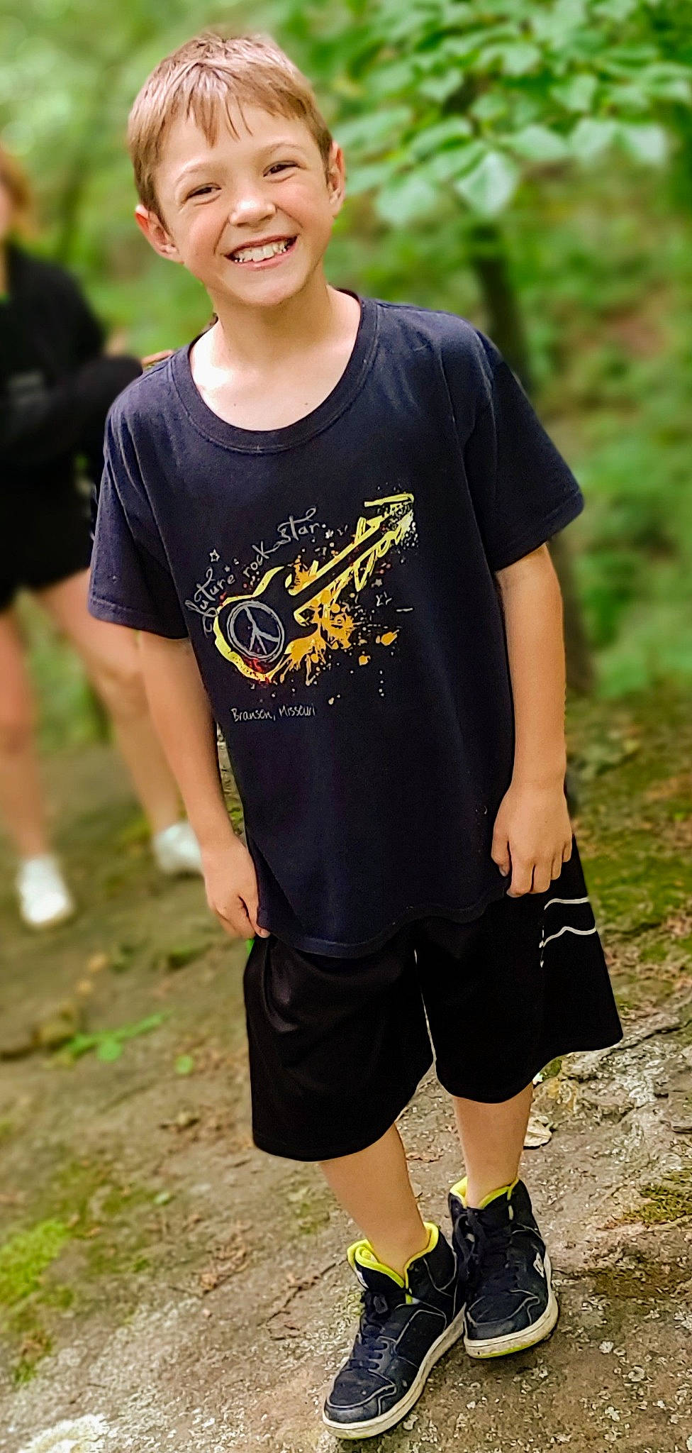 Aidyn is registered to the contest to win money with this photo: active_shirt, black, child, eyewear, grass, happy, joint, joy, leisure, neck, person, shoe, shorts, shoulder, sleeve, smile, sportswear, street_fashion, t_shirt, thigh