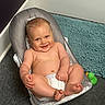 baby, bouncer, diaper, smile, happy, floor, rug, toy, rubber_duck, child, indoor, skin, barefoot, cute, infant, seat, play, young, person, room