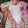 Imani-Leiih is registered to the contest to win money with this photo: baby, infant, bottle, feeding, tattoo, arm, headband, onesie, blanket, striped, floral, pink, socks, hand, person, clothing, lying_down, indoor, cute, newborn