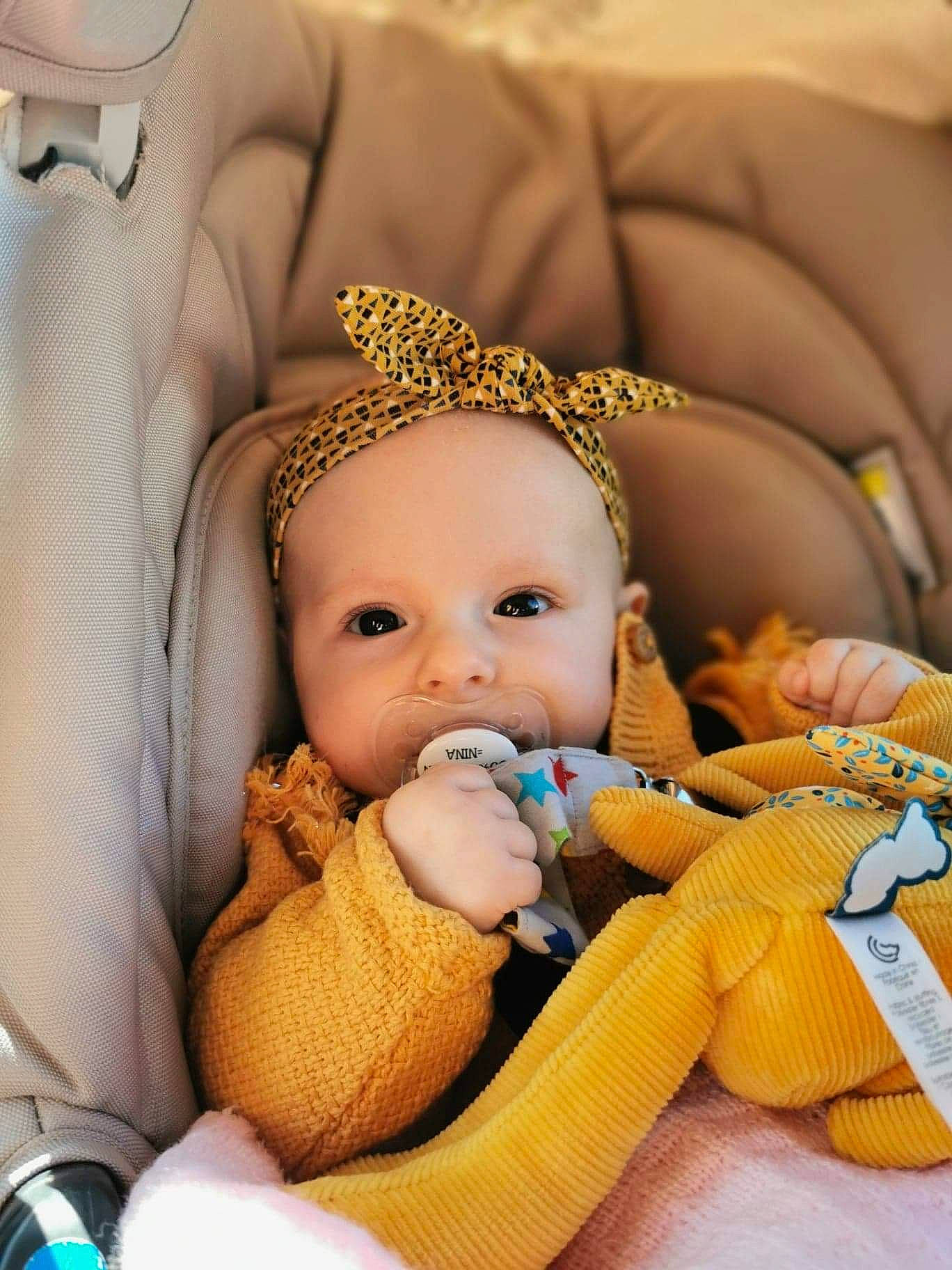 Nina participe au concours pour gagner de l'argent avec cette photo : baby, baby_products, baby_sleeping, baby_toddler_clothing, car_seat, cheek, child, comfort, fashion_accessory, happy, human_body, iris, linens, nail, person, product, room, sitting, skin, textile