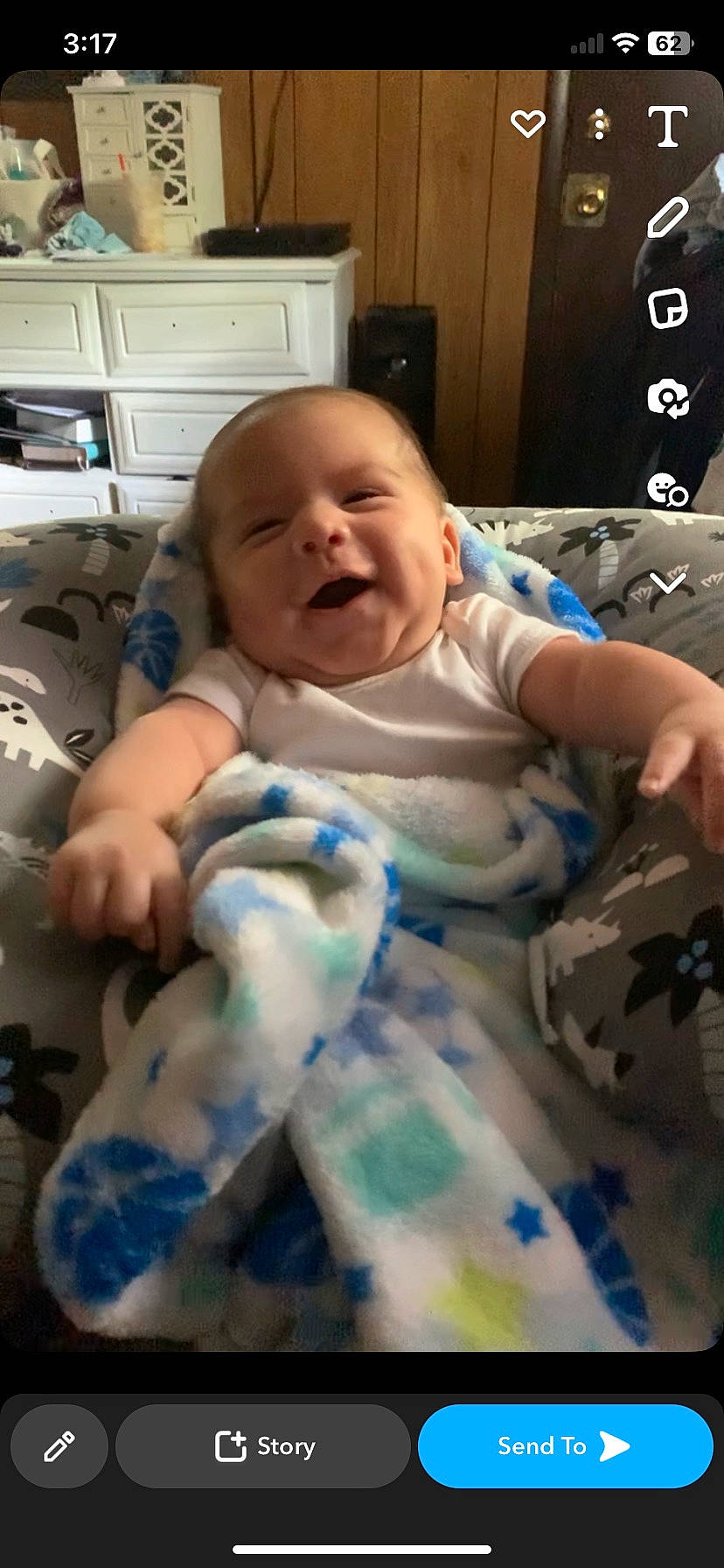 Ares is registered to the contest to win money with this photo: arm, baby, baby_toddler_clothing, cabinetry, cheek, chest_of_drawers, child, comfort, drawer, happy, home_appliance, kitchen_appliance, mouth, person, room, sitting, skin, smile, television, thumb