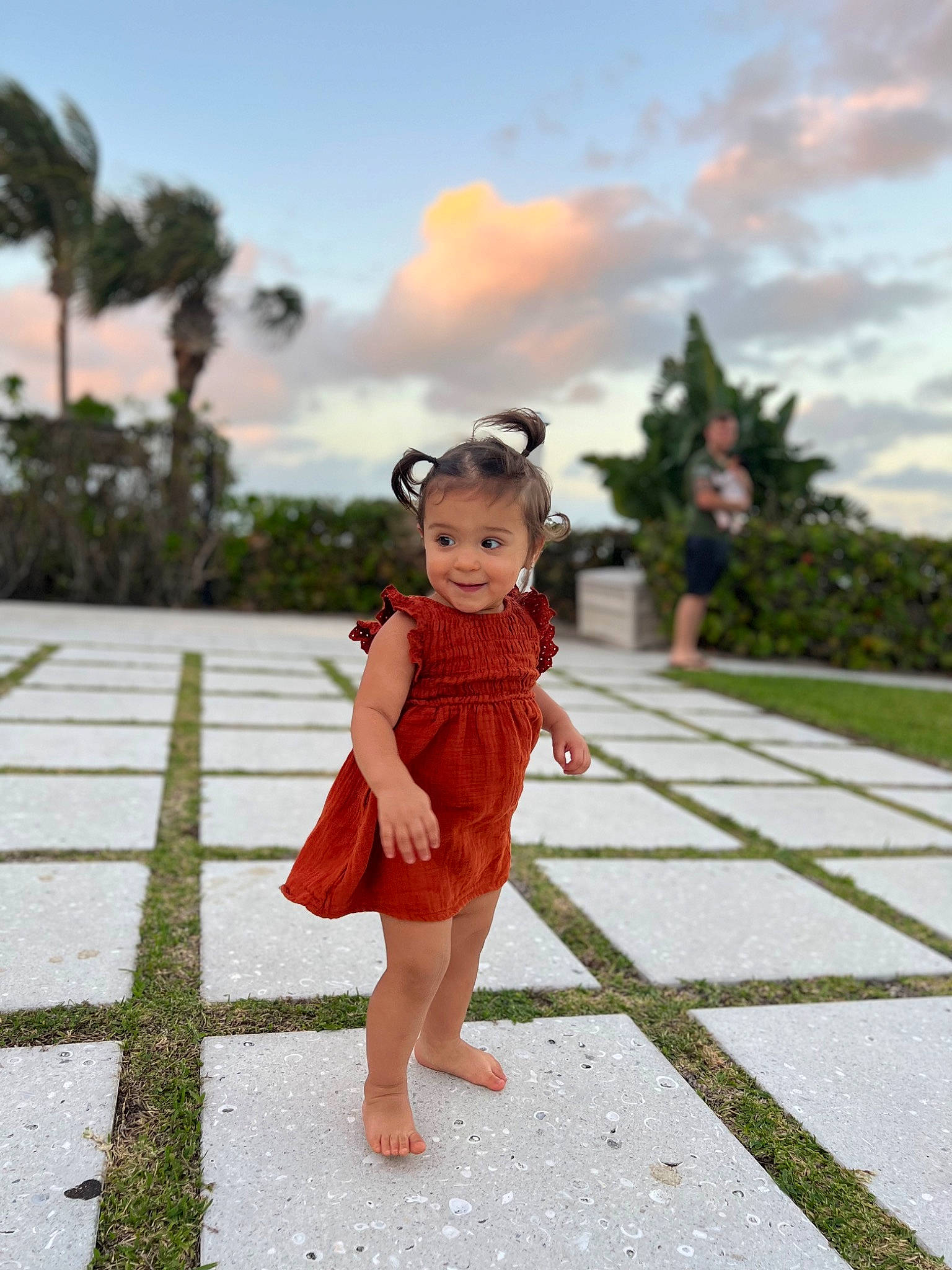 Nalani is registered to the contest to win money with this photo: cloud, dress, flooring, formal_wear, fun, grass, happy, human_leg, joy, leg, leisure, one_piece_garment, palm_tree, people_in_nature, person, plant, recreation, sky, toy, travel