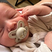 Liyam participe au concours pour gagner de l'argent avec cette photo : baby, infant, pacifier, sleeping, blanket, hand, face, clothing, bed, newborn, soft, cute, peaceful, closeup, skin, person, rest, indoors, child, comfort
