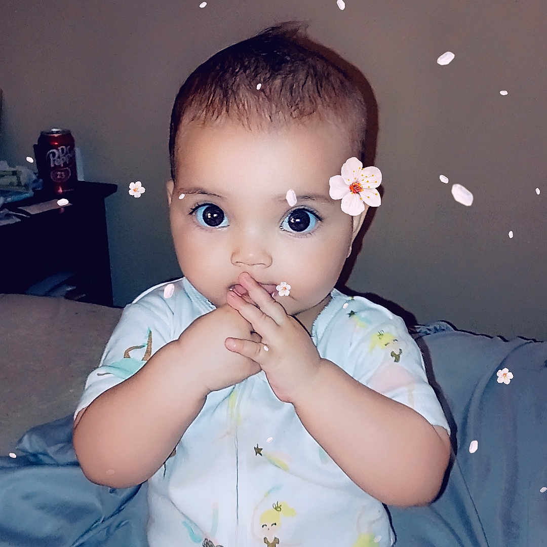 Isobelle is registered to the contest to win money with this photo: baby, bodypart, clothing, couch, dress, eating, face, finger, flower, food, furniture, hand, happy, head, person, photography, plant, portrait, sitting, smile