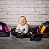 Lenny participe au concours pour gagner de l'argent avec cette photo : baby, child, helmet, motorcycle_gear, jacket, gloves, smile, indoor, floor, brick_wall, portrait, happy, casual_clothing, helmet_visor, reflection, modern, cute, person, headwear, protective_gear