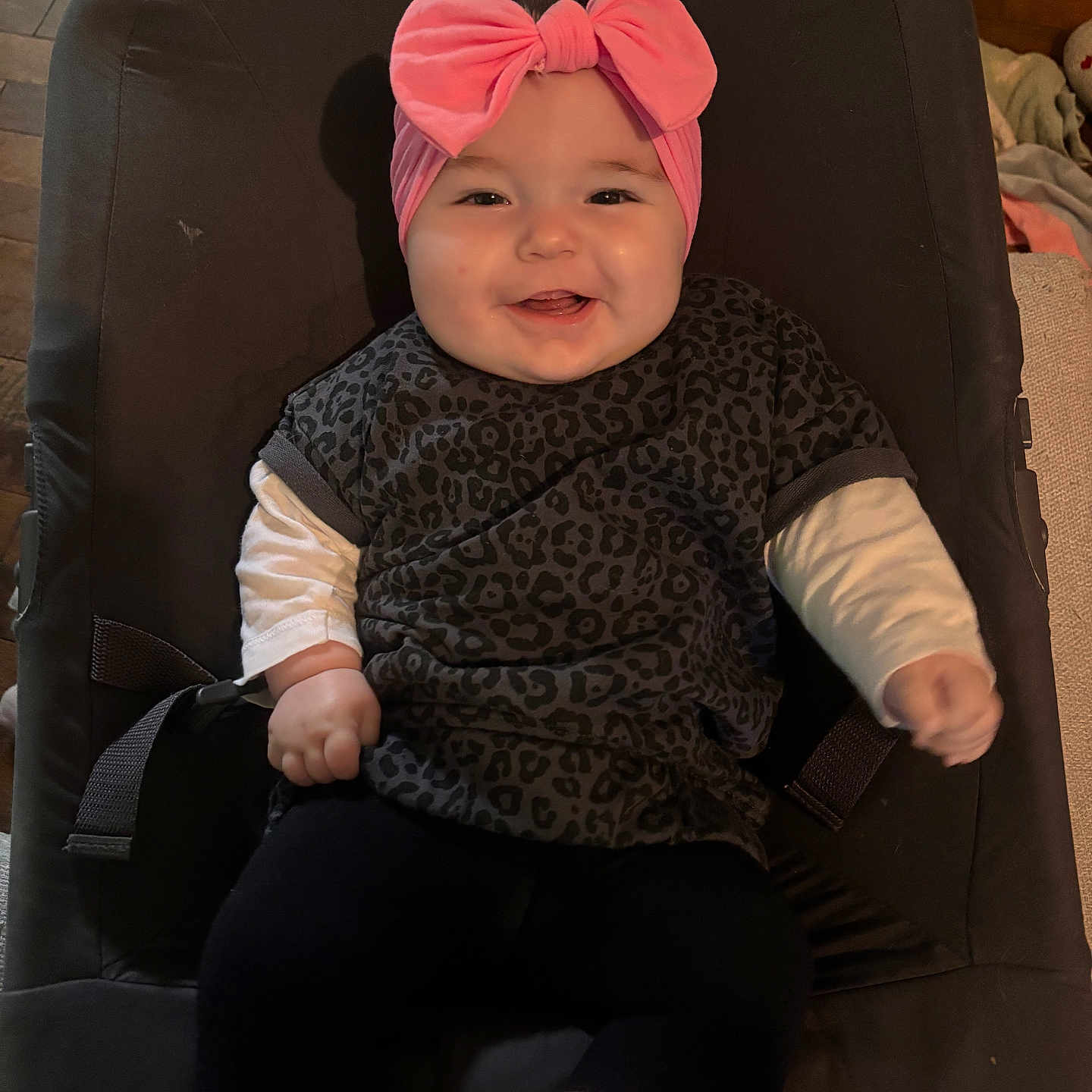 Noëlya participe au concours pour gagner de l'argent avec cette photo : baby, baby_seat, child, clothing, comfortable, cushion, cute, happy, headband, indoor, infant, legs, leopard_print, person, pink, portrait, seat, shirt, smiling, wooden_floor