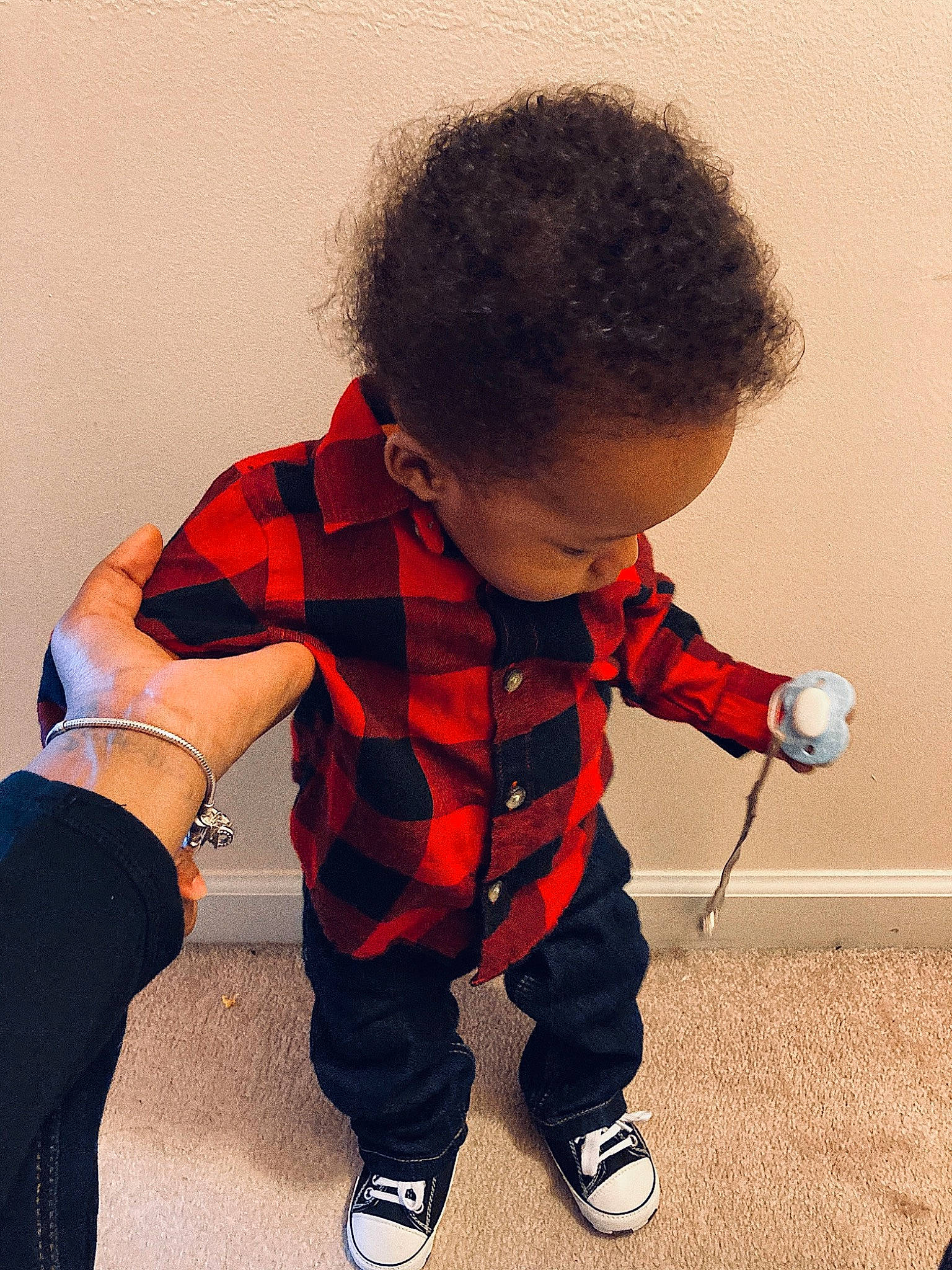 Rico is registered to the contest to win money with this photo: arm, baby, baby_toddler_clothing, finger, flooring, fun, gesture, hairstyle, human_body, knee, leg, outerwear, pattern, person, plaid, shoe, sleeve, sneakers, t_shirt, tartan