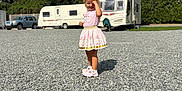Christiana joined the competition — help win amazing prizes! child, girl, pink_dress, pink_shoes, gravel, outdoor, sunny, daylight, car, trailer, camper, trees, sky, clouds, playing, standing, shadow, smiling, happy, nature