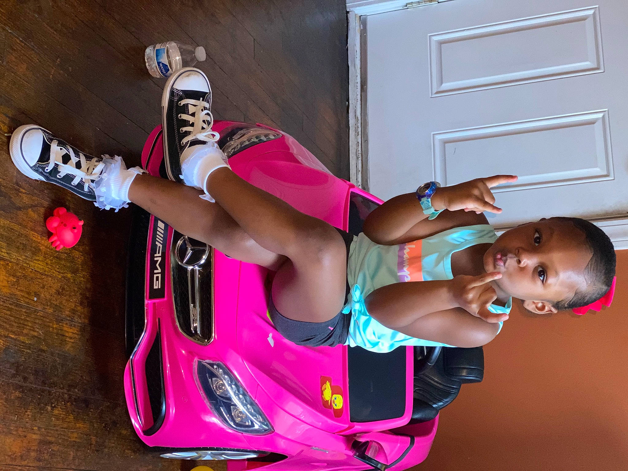 Aubree is registered to the contest to win money with this photo: arm, automotive_design, automotive_exterior, automotive_lighting, bumper, door, human_leg, land_vehicle, leisure, motor_vehicle, person, pink, sandal, shorts, sunglasses, thigh, tire, vehicle, vehicle_door, wheel