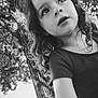 Shannon participe au concours pour gagner de l'argent avec cette photo : black_and_white, casual_clothing, child, curiosity, curly_hair, daylight, expression, face, fence, innocence, looking_up, nature, outdoor, park, person, portrait, summer, sunlight, tree, young