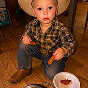 Xzavier joined the competition — help win amazing prizes! child, cowboy_hat, plaid_shirt, jeans, boots, floor, wooden_floor, food, chicken_tenders, paper_plate, colander, indoor, kneeling, person, young_child, snack_time, casual, brown, cute, portrait