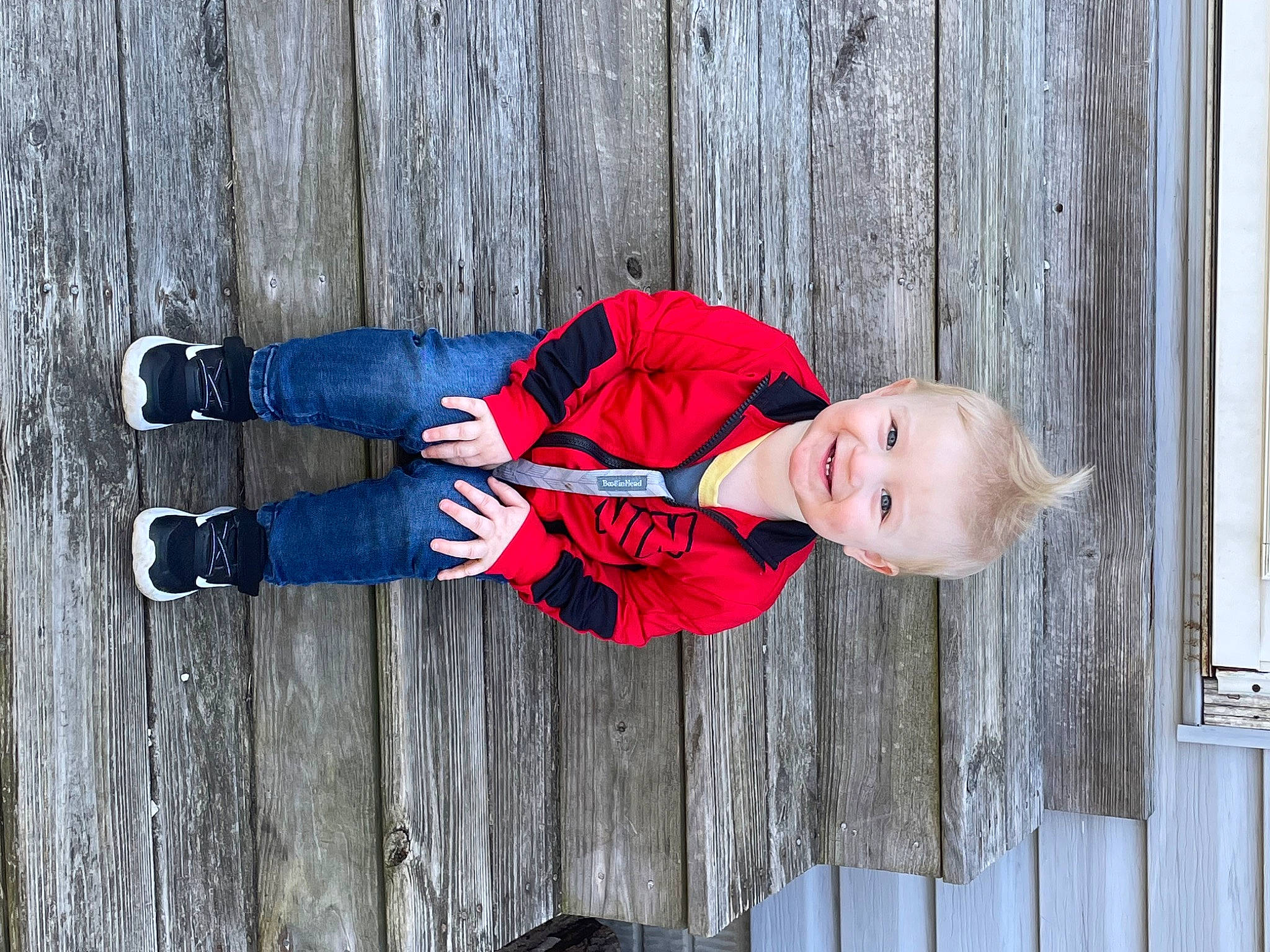 Brendan is registered to the contest to win money with this photo: baby_toddler_clothing, carmine, child, denim, electric_blue, hat, joy, knee, outdoor_shoe, pattern, people_in_nature, person, plant, red, sitting, sleeve, toddler, tree, walking_shoe, winter