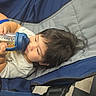 Ryan Mavo joined the competition — help win amazing prizes! child, baby, toddler, infant, stroller, bottle, drinking, sitting, lying_down, portrait, face, hair, eyes, blue_clothing, gray_shirt, outdoor, candid, cozy, transportation, photography