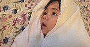 Ryan Mavo is registered to the contest to win money with this photo: adult_hand, baby, bedding, blanket, child, close_up, cozy, cute, eyes, face, floral, gentle, indoor, infant, photography, portrait, soft_texture, towel, wide_eyed, wrapped