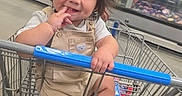 Ryan Mavo is registered to the contest to win money with this photo: toddler, child, smiling, shopping_cart, supermarket, grocery_store, indoor, portrait, sitting, baby, overalls, sneakers, black_hair, face, person, adult, freezer_aisle, shopping, happy, playful