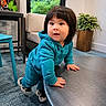 toddler, child, baby, face, portrait, curious, surprised, climbing, sitting, teal_clothing, hoodie, sneakers, table, chair, plant, window, indoors, furniture, carpet, playful
