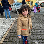 Paul a rejoint le concours — aidez-le/la à gagner de superbes lots ! adult, building, car, casual, child, child_in_costume, cobblestone, costume, curious_expression, curly_hair, daylight, group, jacket, outdoor, people, sidewalk, spiderman_pants, street, urban, winter_clothing
