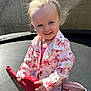 Ellie is registered to the contest to win money with this photo: toddler, child, smiling, toy_guitar, outdoor, trampoline, pink_clothing, butterfly_pattern, sunlight, happy, playful, hair, face, footwear, jacket, person, kids, playing, cute, young_child