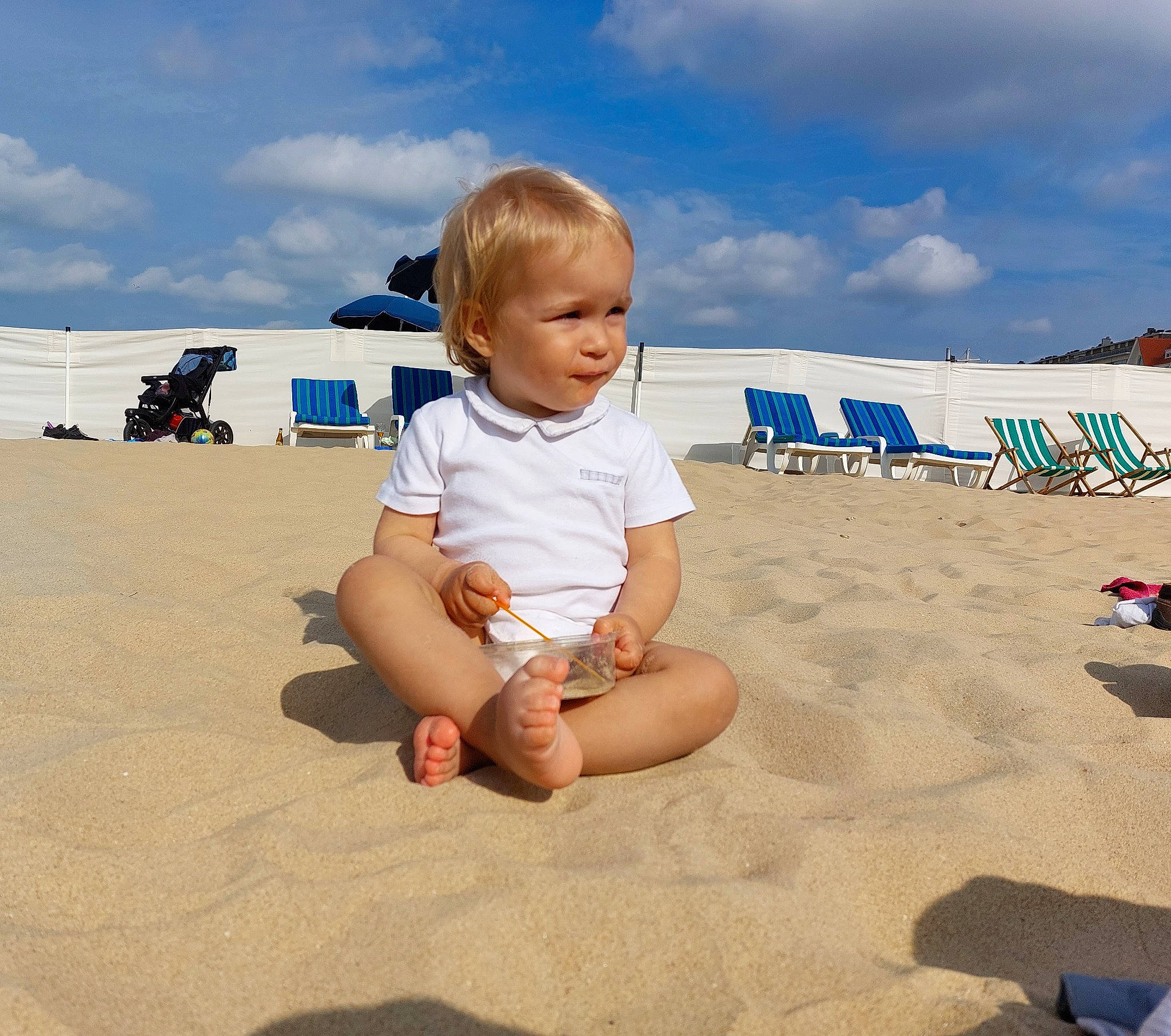 Sidney a rejoint le concours — aidez-le/la à gagner de superbes lots ! baby, baby_toddler_clothing, beach, child, cloud, foot, fun, happy, horizon, landscape, leisure, people_on_beach, person, sand, shorts, singing_sand, sitting, sky, summer, toddler