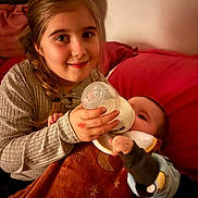 Shanna participe au concours pour gagner de l'argent avec cette photo : child, baby, girl, feeding, bottle, blanket, couch, indoor, smile, braid, comfort, infant, young, clothing, cozy, family, portrait, warm_light, home, care