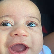 Joseph is registered to the contest to win money with this photo: baby, close_up, face, smiling, happy, infant, cute, skin, eyes, mouth, expression, child, portrait, natural_light, young, person, clothing, white_shirt, eyelashes, joy