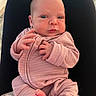baby, infant, pink_onesie, newborn, person, hands, feet, lap, legs, clothing, skin, face, expression, indoors, human, cute, small, young, resting, curious