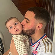 Elya a rejoint le concours — aidez-le/la à gagner de superbes lots ! affection, baby, beard, casual, child, close_up, cute, face, family, head, holding, indoor, kiss, love, man, person, portrait, short_hair, skin, striped_clothing