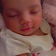 Jazaria joined the competition — help win amazing prizes! baby, sleeping, infant, portrait, close_up, face, closed_eyes, peaceful, blanket, pink_blanket, white_clothing, shirt, red_text, indoor, cozy, resting, sitting, soft_lighting, photography, newborn