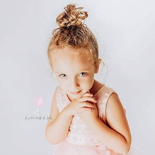 Iliana participe au concours pour gagner de l'argent avec cette photo : baby_toddler_clothing, bridal_accessory, brown_hair, day_dress, ear, eyebrow, eyelash, flash_photography, gesture, happy, headpiece, jewellery, lip, long_hair, neck, person, shoulder, skin, sleeve, smile