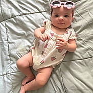 Mckenna joined the competition — help win amazing prizes! baby, child, infant, onesie, strawberry_pattern, pink_sunglasses, flower_shaped_sunglasses, blanket, bed, soft_texture, cute, lying_down, portrait, human, baby_clothing, indoor, skin, face, headwear, relaxed