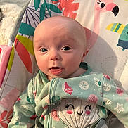 Cora is registered to the contest to win money with this photo: applique, baby, blanket, bodypart, clothing, cushion, face, finger, furniture, hand, hat, head, homedecor, newborn, pattern, person, photography, portrait, sitting, t_shirt