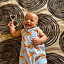 Jakai joined the competition — help win amazing prizes! baby, child, smiling, lying_down, sunglasses, clothing, patterned_outfit, blanket, spiral_pattern, infant, happy, cute, playful, tongue_out, hand, skin, head, eyes_closed, indoors, relaxed